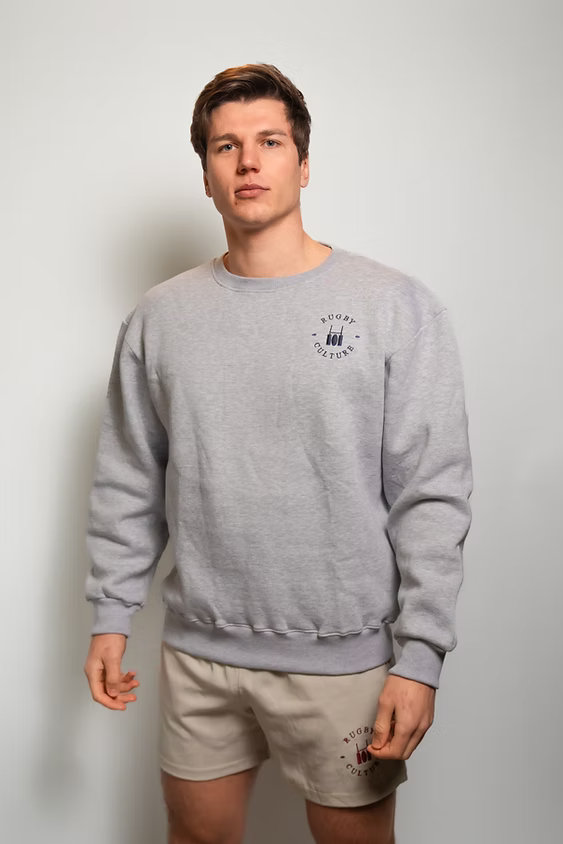 Rugby Culture Grey Sweatshirt worn by a male model with beige shorts, front view