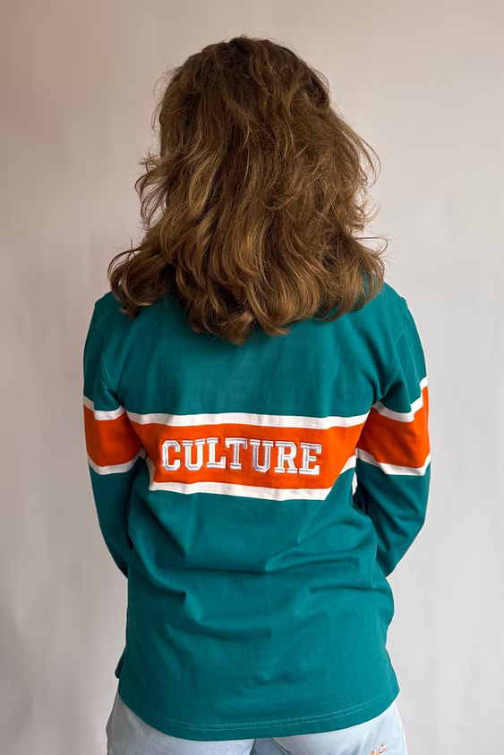 Female model wearing the Rugby Culture Teal & Orange Rugby Polo, back view