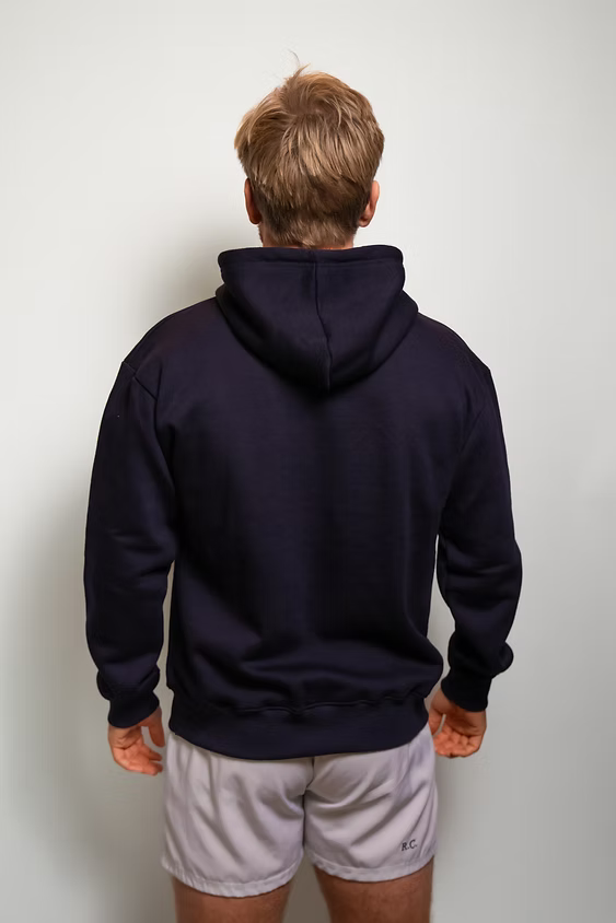 Rugby Culture Navy Blue Hoodie worn by a male model with grey shorts, back view