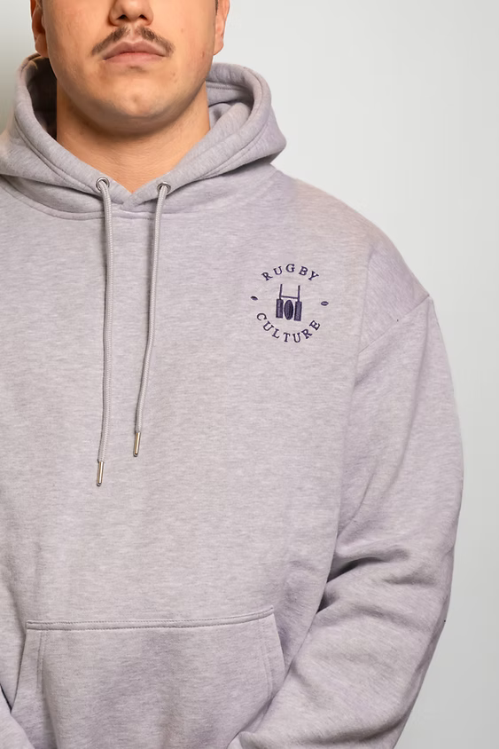 Rugby Culture Grey Hoodie worn, close-up of the chest emblem