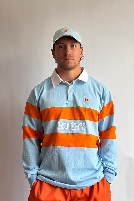 Male model wearing the Rugby Culture Sky Blue & Orange Rugby Polo, front view