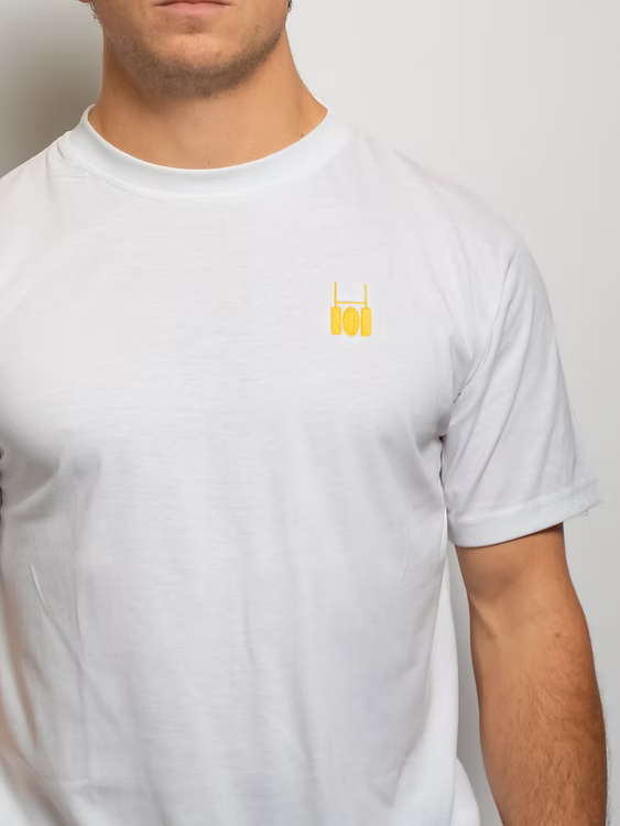 Rugby Culture White Basic Logo T-Shirt worn by a male model, close-up of the embroidered crest
