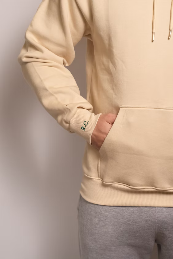 Rugby Culture Beige Hoodie worn, close-up with hand in the front pocket