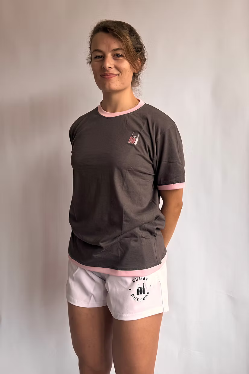 Rugby Culture Deep Grey & Pink Logo T-Shirt worn by a female model, front view, small pink crest on the chest