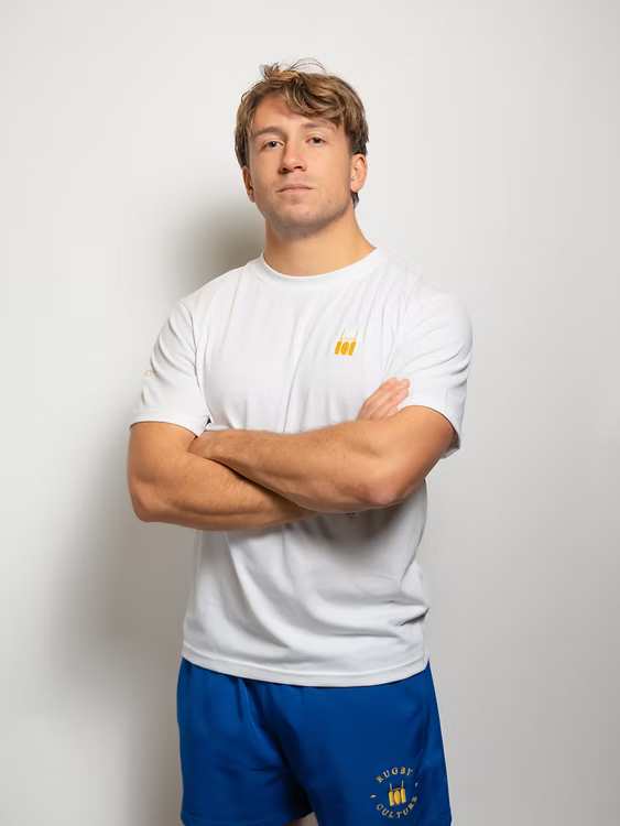 Rugby Culture White Basic Logo T-Shirt worn by a male model with arms crossed, front view